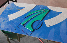 The green portions of the logo were cut out of another green sign and placed upon the blue back drop.