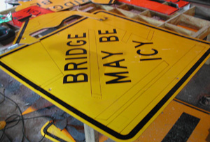 A Yellow bridge might be icy sign with sshapes traced on its surface.  In this senario the traced shapes do not overlap the lettered portions.