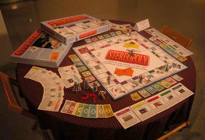 The stereoploy game is shown set up with the card, board, pieces, and box present on a table in the art gallery at Allegheny College